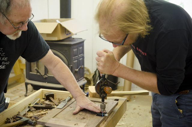 David Ray Pine teaching a student how to drill a door lock in a woodworking school