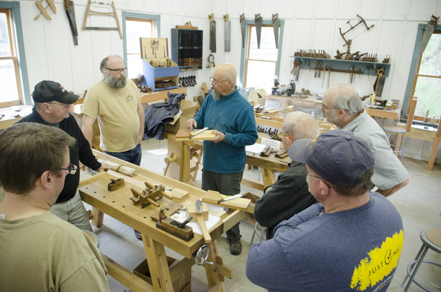Restoring Wooden Hand plane class with students surrounding Bill Anderson to look at handplane resoration