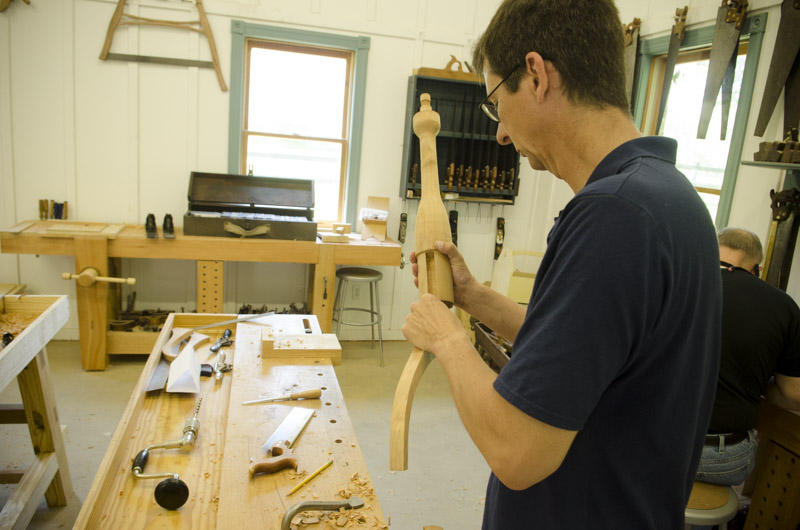 a male woodworking student fitting his sliding dovetail table legs to the spindle at his workbench at Joshua Farnsworth's Wood And Shop Traditional Woodworking School