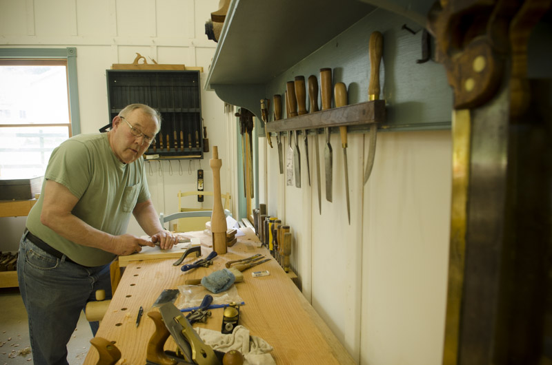 a woodworking student using a chisel at his Roubo workbench at Joshua Farnsworth's Wood And Shop Woodworking School
