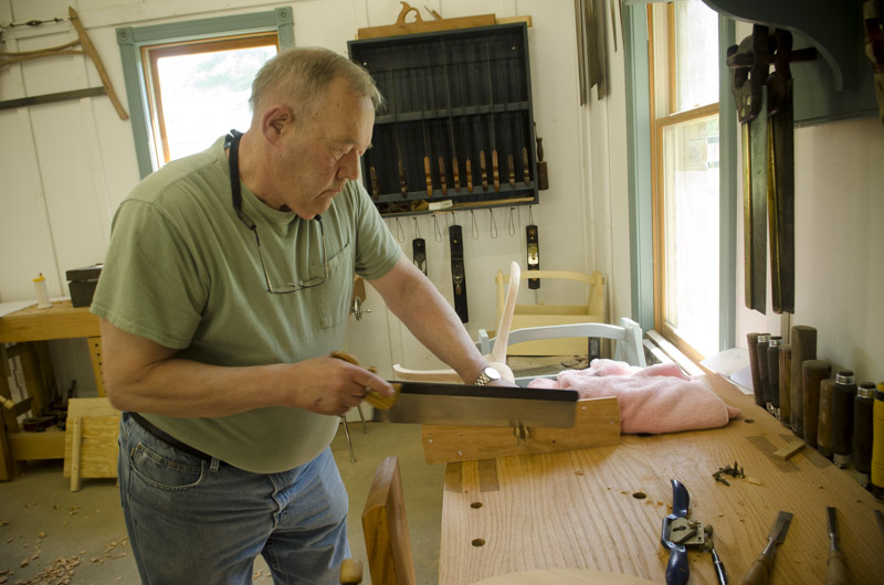 a woodworking student using a dovetail saw at his roubo workbench at Joshua Farnsworth's Wood And Shop Woodworking School