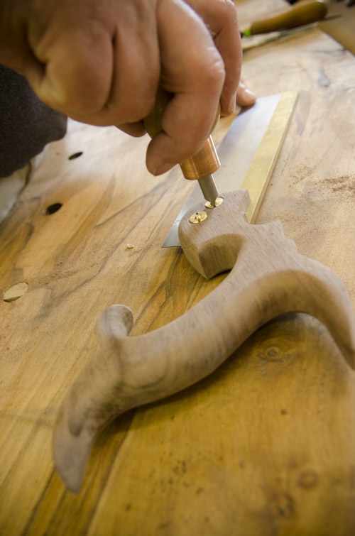 A woodworking student tightening backsaw nuts on a new dovetail saw at Joshua Farnsworth's Wood And Shop Traditional Woodworking School