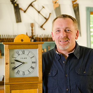 Will Myers woodworking instructor at the woodandshop traditional woodworking school with a Isaac Youngs reproduction shaker wall clock