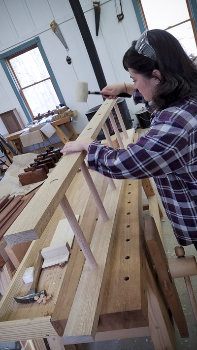 Lady using a rubber mallet to assemble an oak ladder in a ladder making class